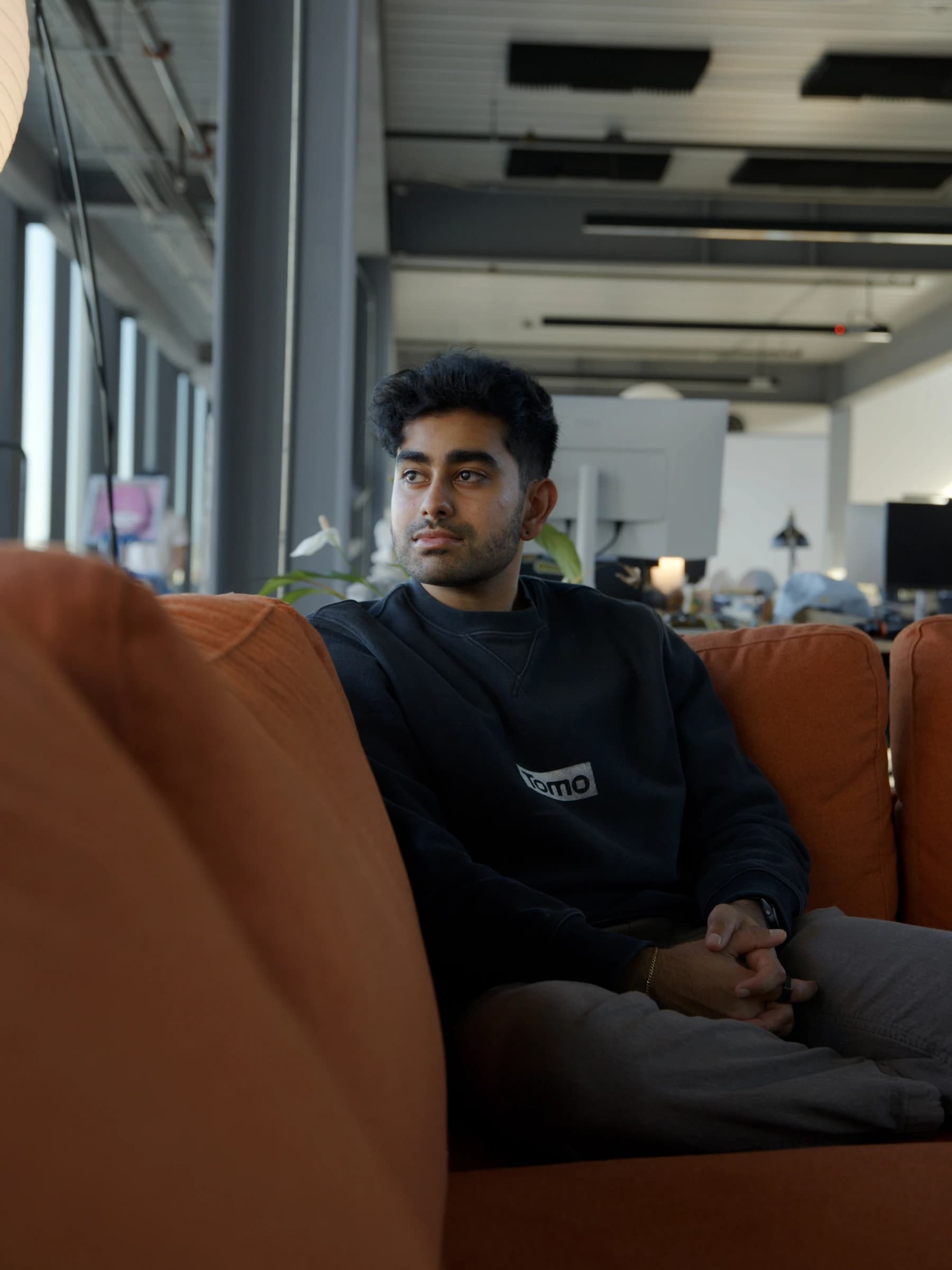 Team members talking on the orange couch
